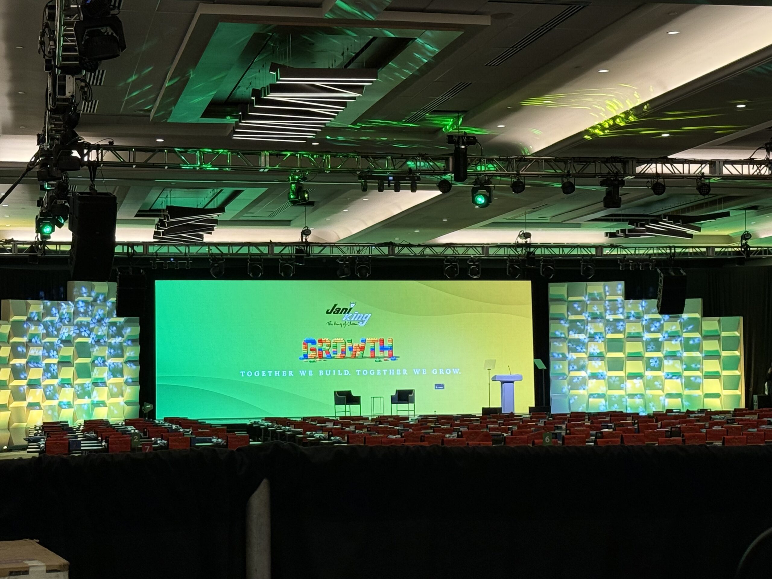 Conference stage setup with colorful backdrop reading "Growth." Empty seats indicate an upcoming event themed around collaboration and development.